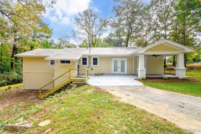 back of house with french doors, ceiling fan, and a lawn