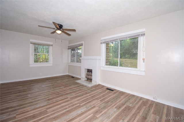 unfurnished living room with ceiling fan, a textured ceiling, and hardwood / wood-style floors