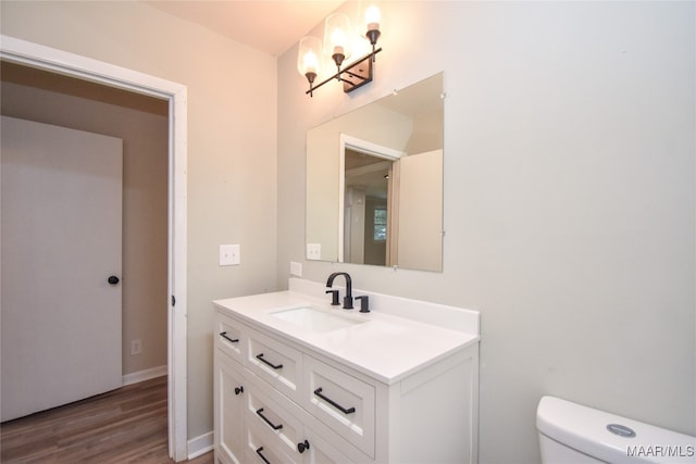 bathroom featuring toilet, hardwood / wood-style flooring, and vanity