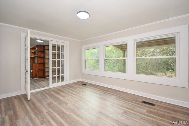 spare room with ornamental molding and hardwood / wood-style floors