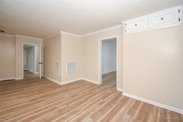 empty room featuring light hardwood / wood-style flooring and ornamental molding