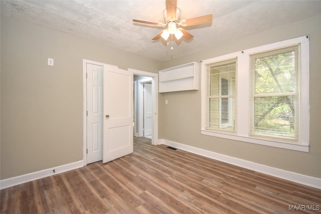 unfurnished bedroom with a textured ceiling, hardwood / wood-style flooring, and ceiling fan