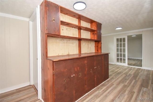 bar featuring ornamental molding, wood walls, and hardwood / wood-style floors