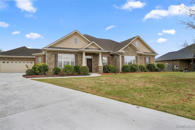 craftsman-style home featuring concrete driveway, a front yard, an attached garage, and brick siding