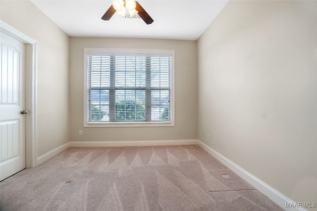 spare room with ceiling fan and light carpet