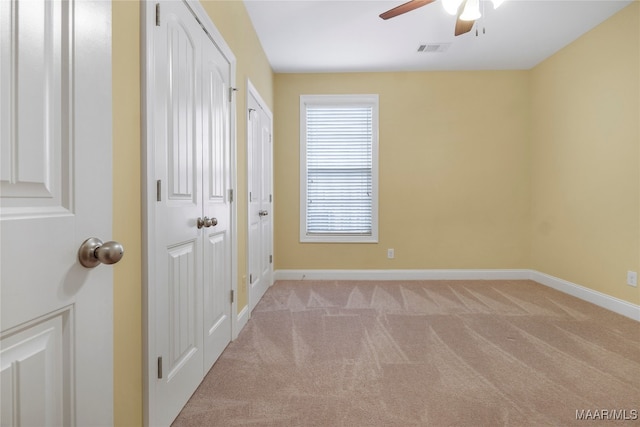 interior space featuring light carpet and ceiling fan