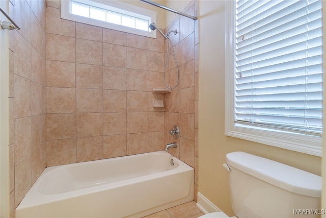 bathroom with tiled shower / bath combo, toilet, and tile patterned flooring