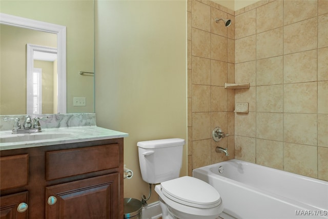 full bathroom featuring toilet, tiled shower / bath, and vanity