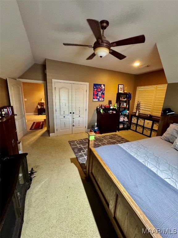 bedroom featuring lofted ceiling, dark carpet, and ceiling fan