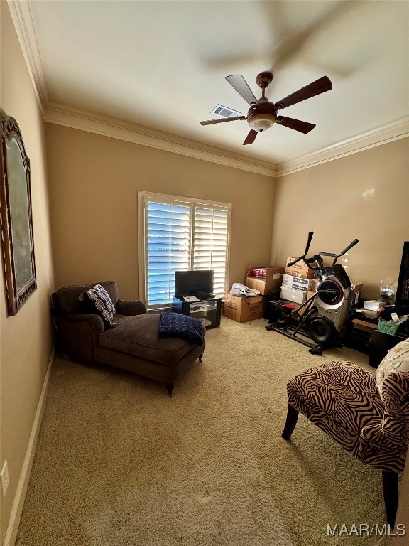 sitting room featuring ornamental molding, carpet, and ceiling fan