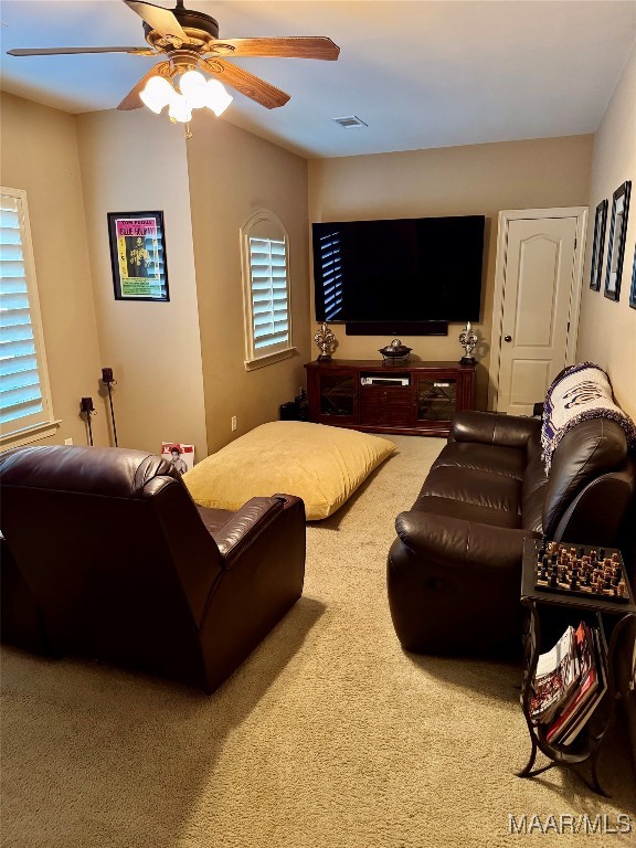 carpeted living room with ceiling fan and a healthy amount of sunlight