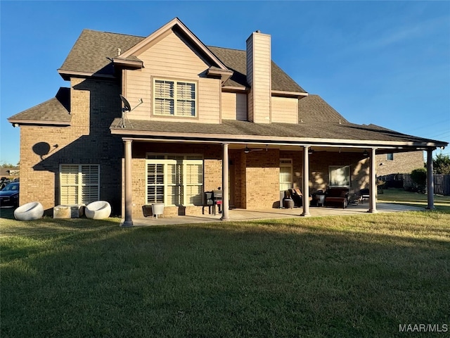 back of property featuring a patio area and a lawn