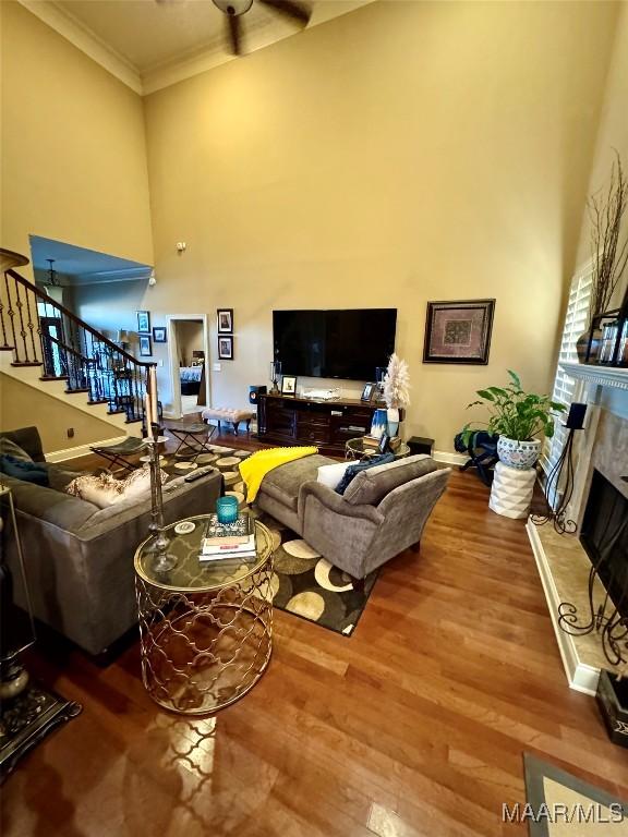 1160 Laurel Brook Ln, Montgomery, AL 36117 - living room featuring a high ceiling, stairs, a fireplace, ornamental molding, and wood finished floors