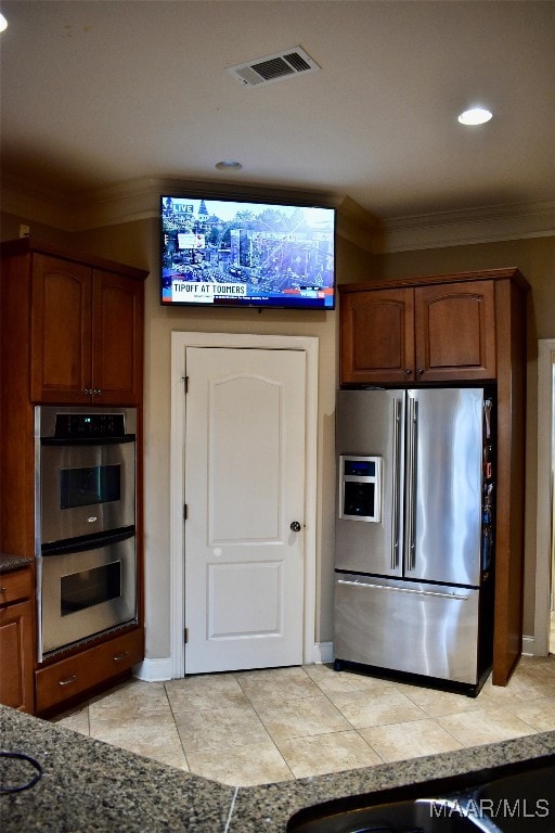 kitchen with crown molding, stainless steel appliances, and light tile patterned flooring