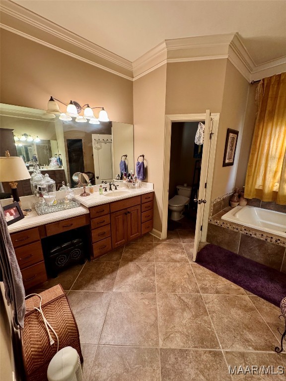 bathroom featuring tiled bath, toilet, vanity, ornamental molding, and tile patterned flooring