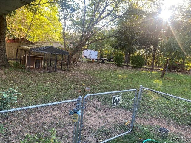 view of yard with a gate, an outdoor structure, and fence private yard