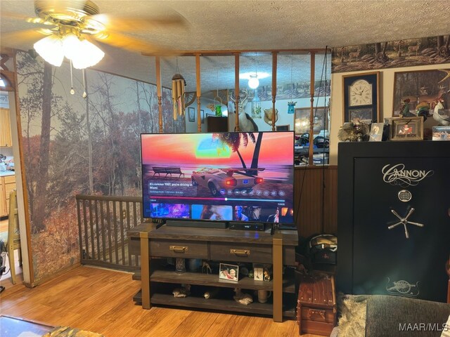 living room featuring hardwood / wood-style floors, ceiling fan, and a textured ceiling