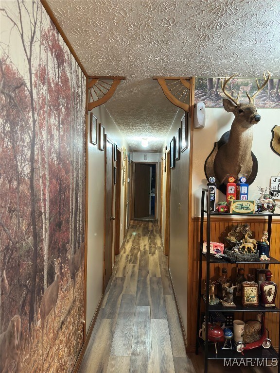 corridor featuring hardwood / wood-style floors and a textured ceiling