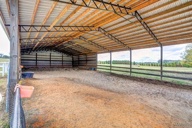 view of horse barn featuring a rural view