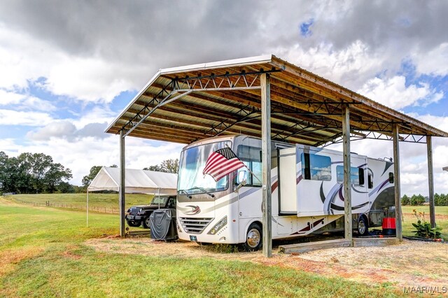 view of vehicle parking with a yard and a carport