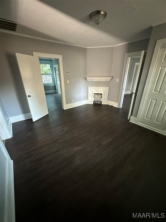 unfurnished living room featuring ornamental molding and dark wood-type flooring