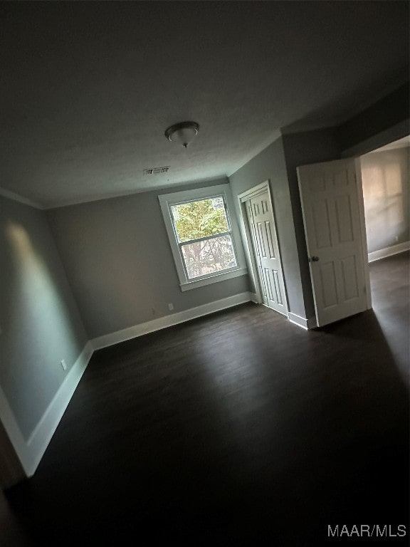 empty room with dark hardwood / wood-style flooring