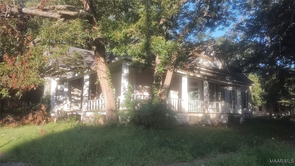 view of side of property featuring covered porch