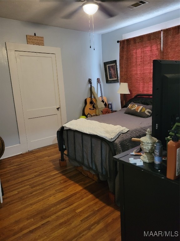 bedroom with ceiling fan and dark hardwood / wood-style floors