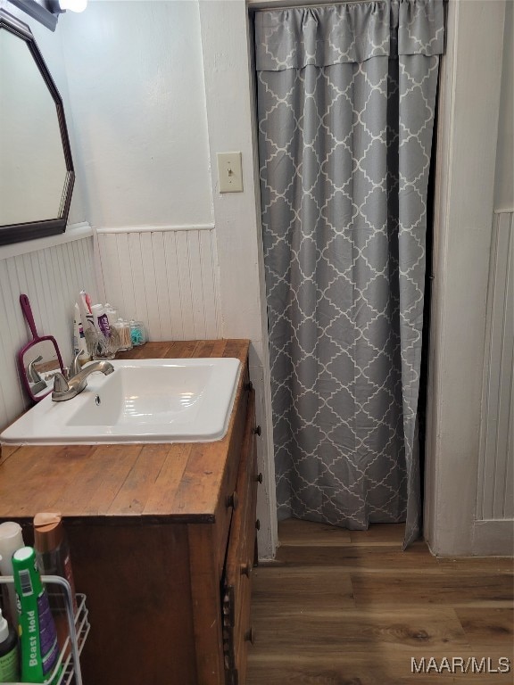 bathroom featuring walk in shower, vanity, and hardwood / wood-style floors