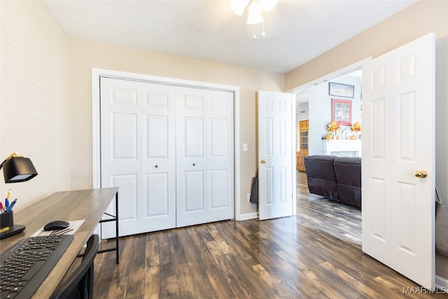 home office with ceiling fan and dark hardwood / wood-style flooring