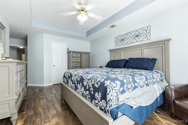 bedroom featuring dark wood-type flooring, ceiling fan, and a textured ceiling