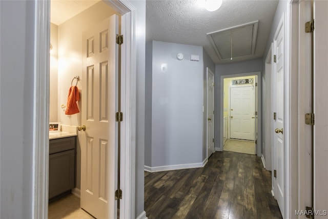 corridor with dark wood-type flooring and a textured ceiling