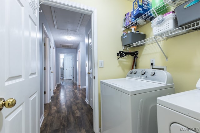 laundry area featuring dark hardwood / wood-style flooring, a textured ceiling, and washer and clothes dryer