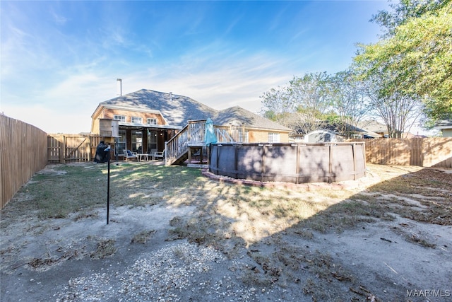 rear view of property with a fenced in pool