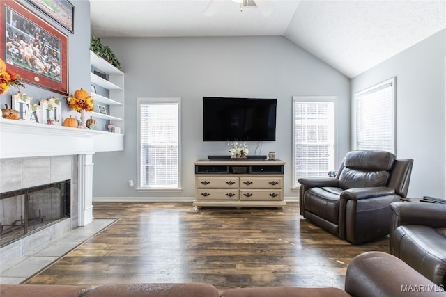 living room with a fireplace, lofted ceiling, a healthy amount of sunlight, and dark hardwood / wood-style flooring