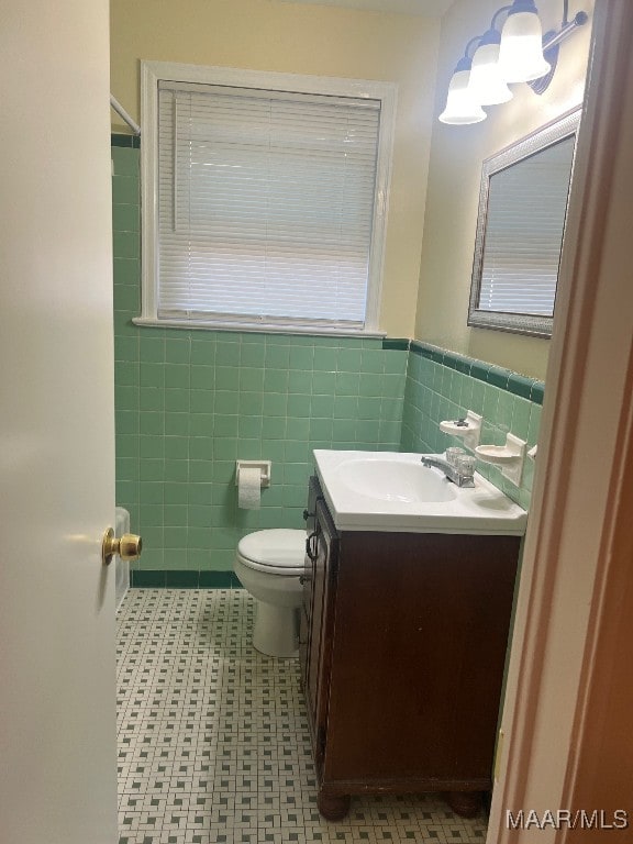 bathroom with tile walls, vanity, and toilet