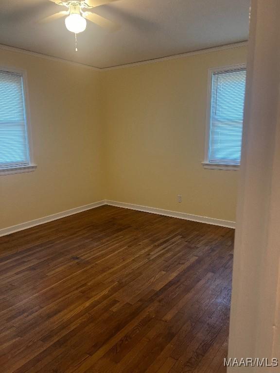 empty room featuring crown molding, ceiling fan, and dark hardwood / wood-style flooring