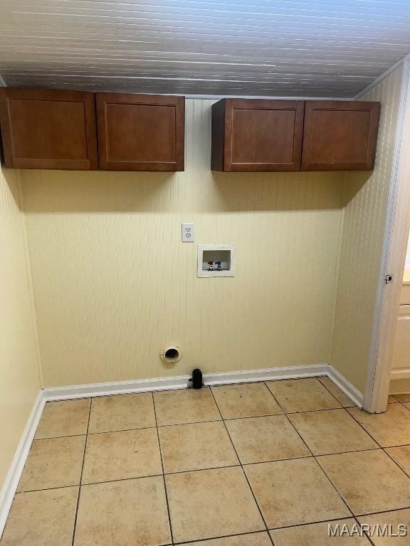 washroom featuring washer hookup, light tile patterned floors, and cabinets