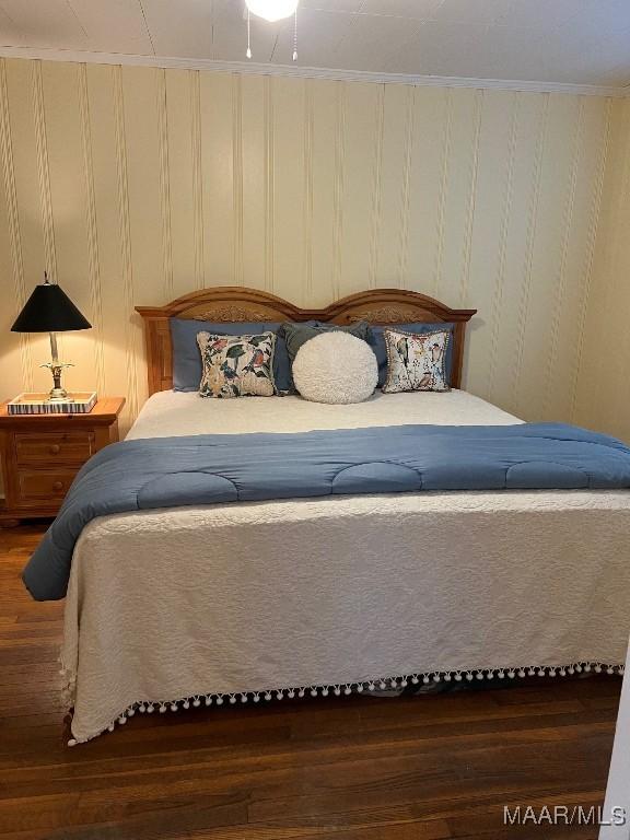 bedroom with crown molding and dark hardwood / wood-style flooring