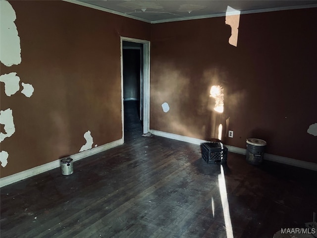 empty room with ornamental molding and dark wood-type flooring