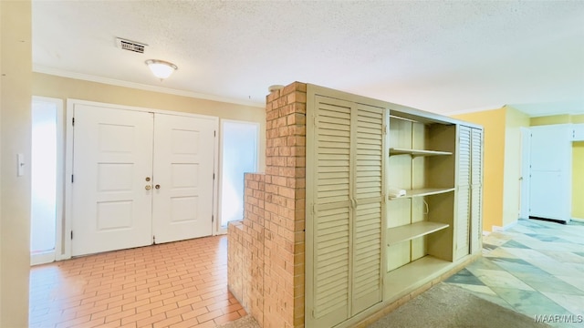 corridor with ornamental molding and a textured ceiling