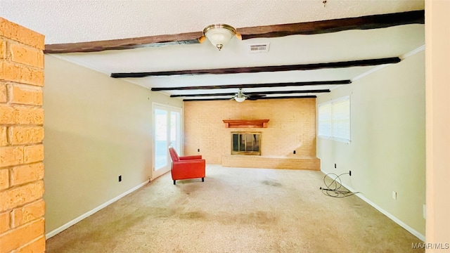 interior space with a healthy amount of sunlight, a large fireplace, carpet, and beam ceiling