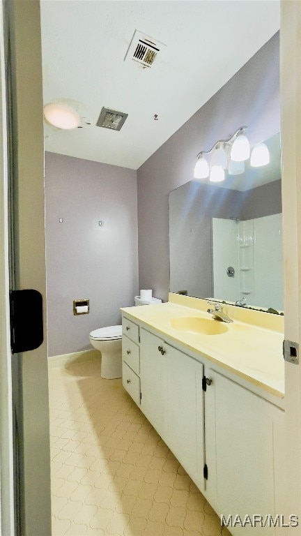 bathroom featuring toilet, vanity, and tile patterned flooring