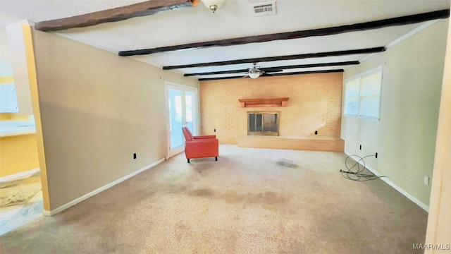 unfurnished living room featuring a wealth of natural light, carpet, ceiling fan, and beam ceiling