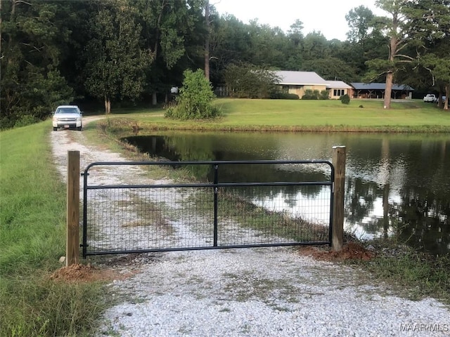 view of gate featuring a lawn and a water view