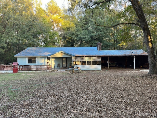 ranch-style home with a wooden deck and a carport