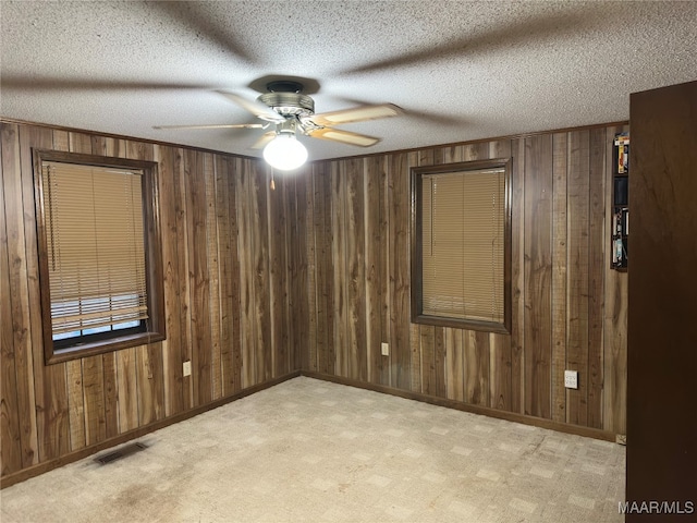 unfurnished room featuring ceiling fan, a textured ceiling, and light carpet