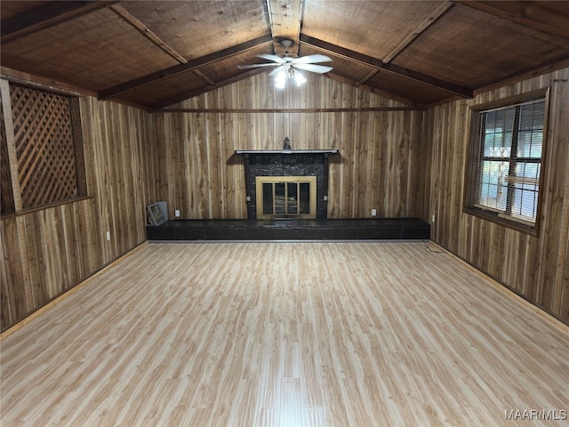 unfurnished living room with wooden walls, vaulted ceiling, wooden ceiling, and light hardwood / wood-style flooring