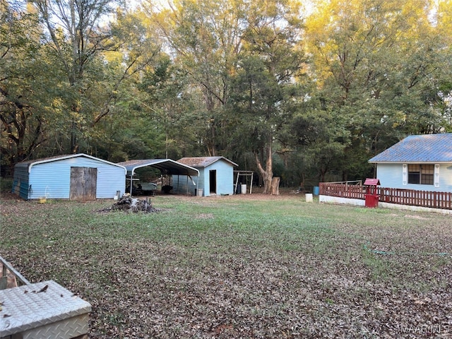 view of yard featuring a carport, a shed, and a wooden deck