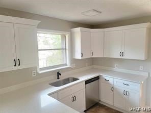 kitchen with stainless steel dishwasher, sink, and white cabinets